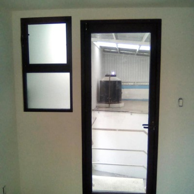 Puerta abatible y ventana tipo proyectable.