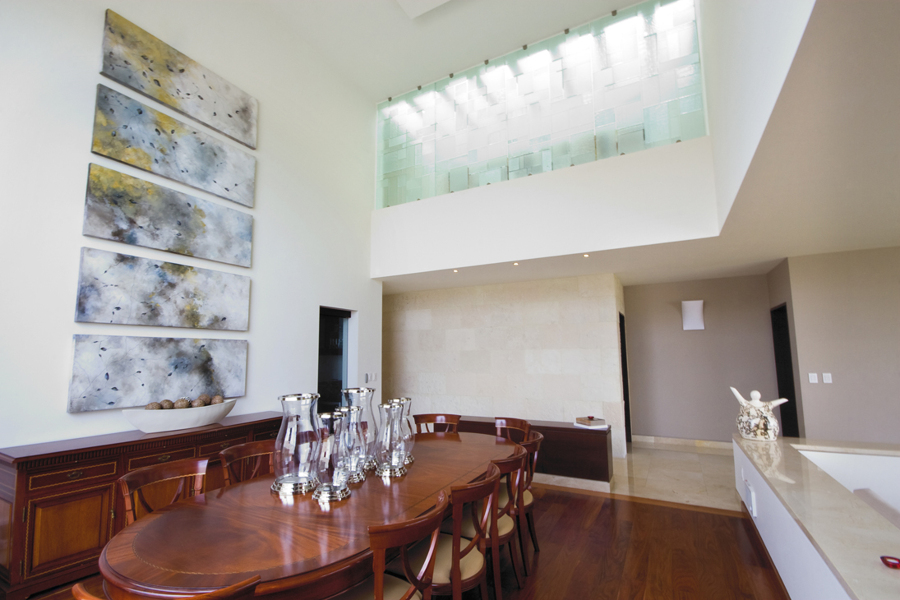 El comedor en doble altura, con vitral monocromático en el pasillo de planta alta