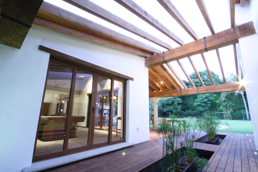 Un deck con espejo de agua integra el salón de juegos con el gimnasio